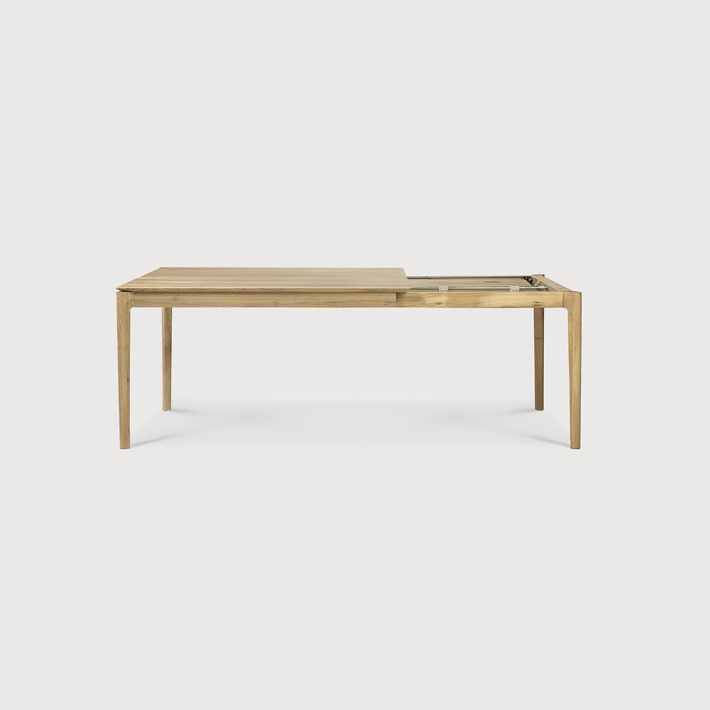 Table à manger extensible contemporaine en chêne massif avec plateau rectangulaire et piètement ajouré pour salle à manger