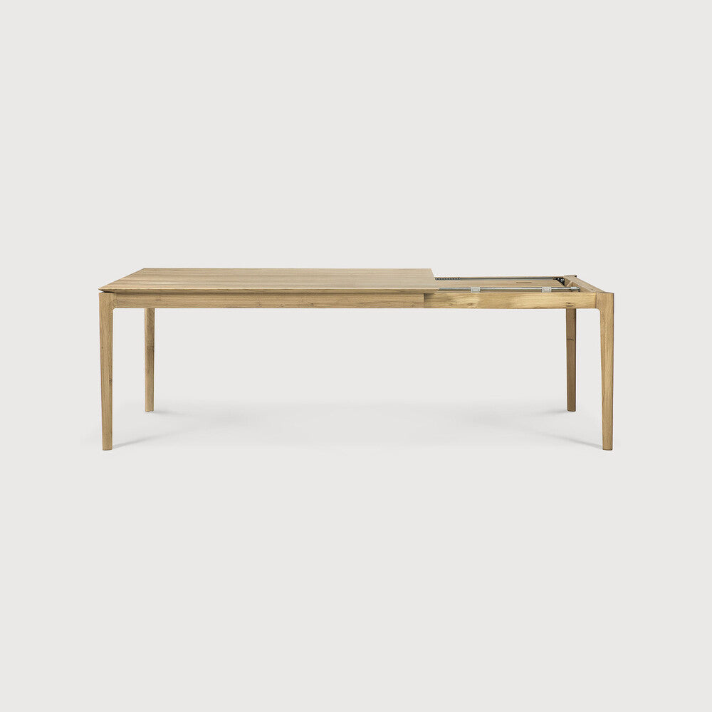 Table à manger extensible contemporaine en chêne massif avec plateau rectangulaire et piètement ajouré pour salle à manger