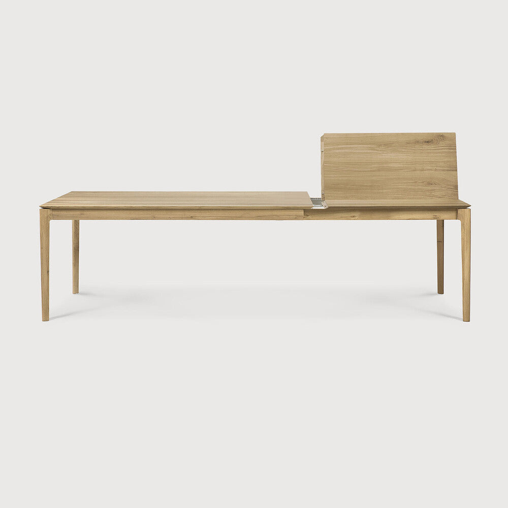 Table à manger extensible contemporaine en chêne massif avec plateau rectangulaire et piètement ajouré pour salle à manger