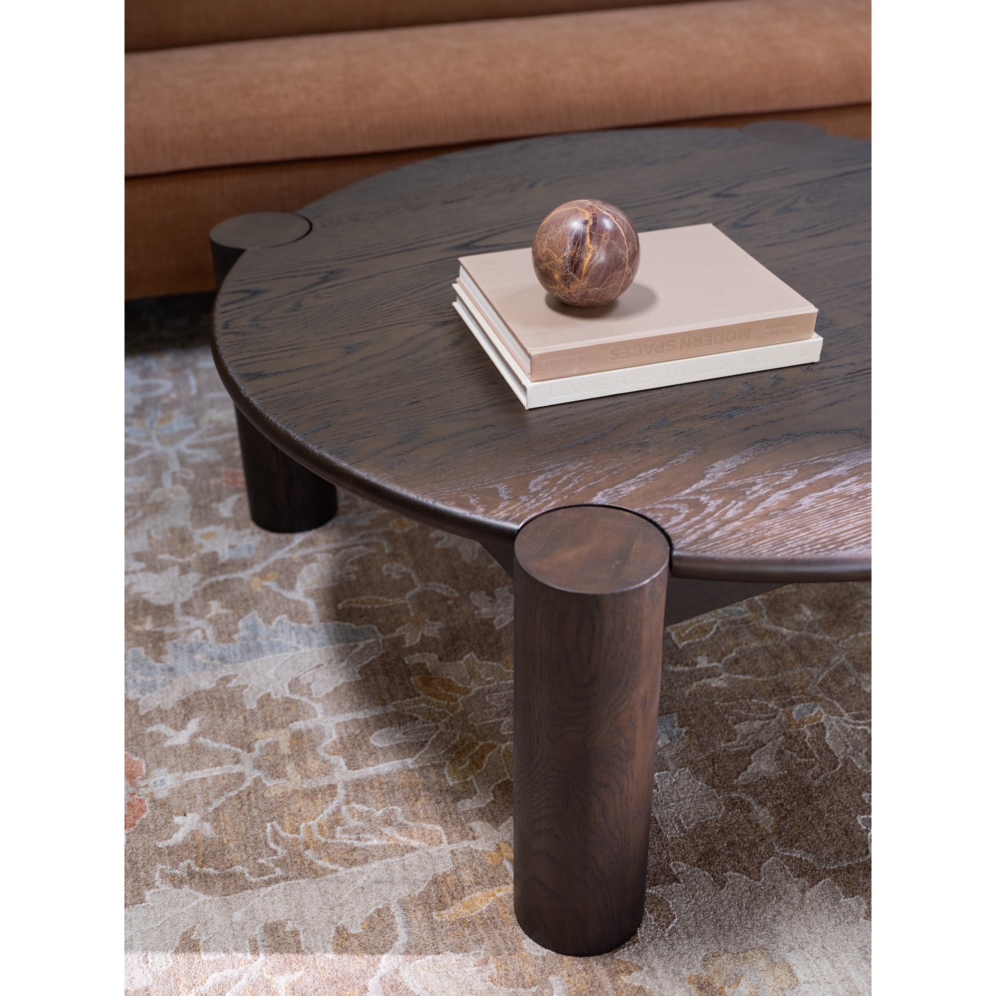 Table basse organique moderne en chêne massif avec plateau rond à bord arrondi et pieds colonne pour salon