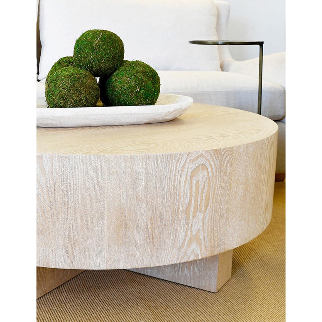 Table basse scandinave en chêne cérusé avec plateau rond épais et piètement en croix pour le salon
