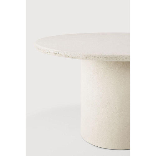 Table de salle à manger artisanale en micro-ciment avec plateau rond texturé effet pierre naturelle
