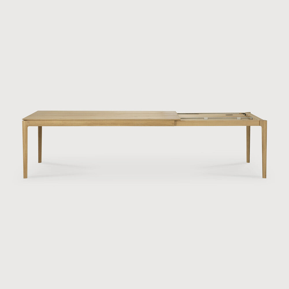 Table à manger extensible contemporaine en chêne massif avec plateau rectangulaire et piètement ajouré pour salle à manger